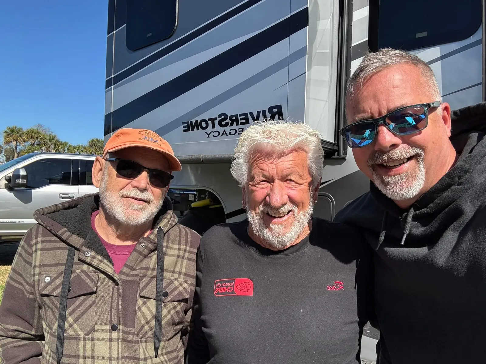 Friends visiting together beside an RV at Endless Summer Campground